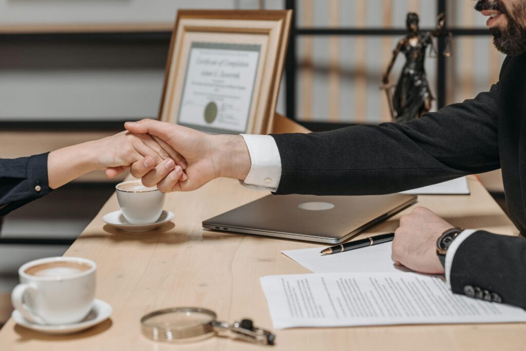 pexels-photo-8112180-8112180 A formal handshake over a business contract in a corporate office setting.